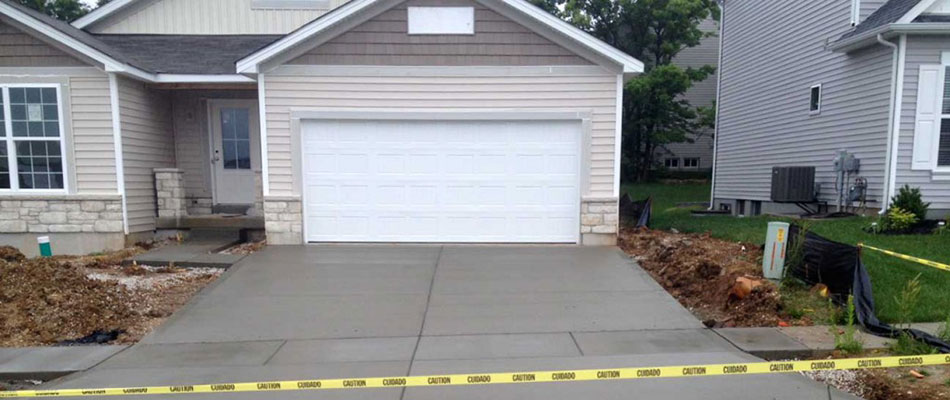 Poured concrete driveway installed by J.T. & Sons Lawn Care at a home in Bloomington, IL.